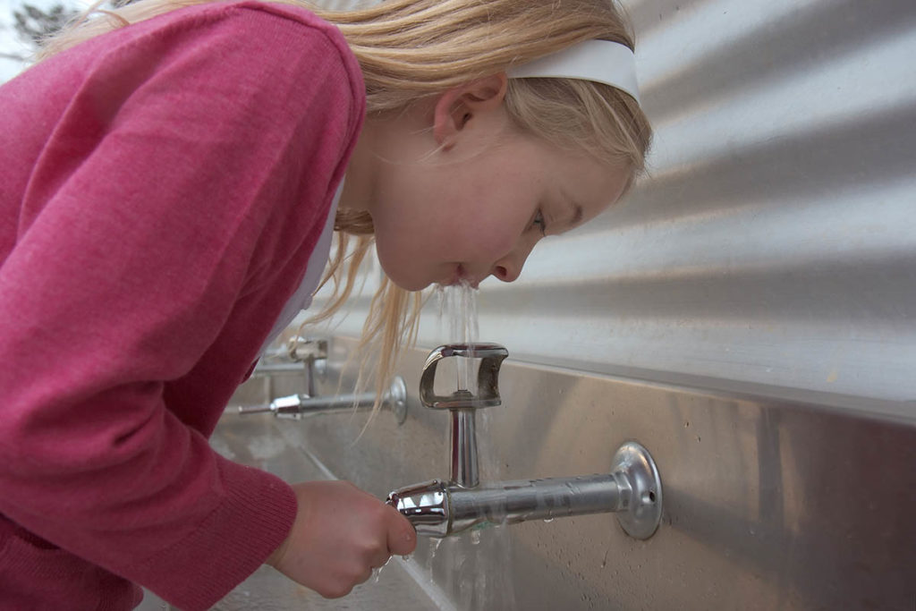 School student drinks from bubbler