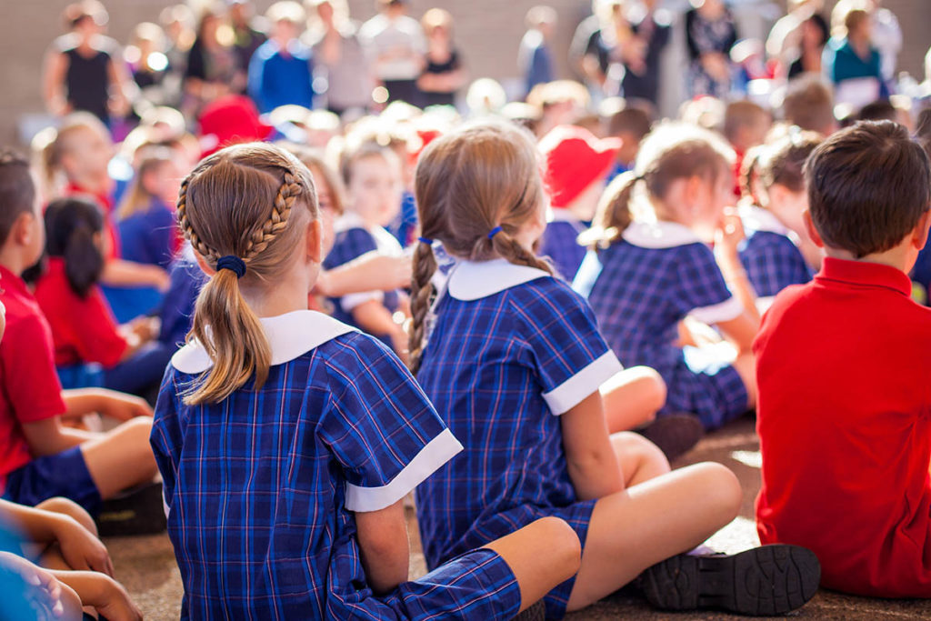 Schoolkids in assembly in summer uniform