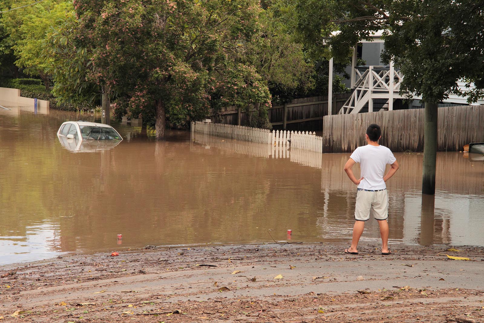 Man staring at a submerged car during Brisbane Floods