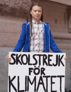 An image of Greta Thunberg holding her original school strike for climate sign. 