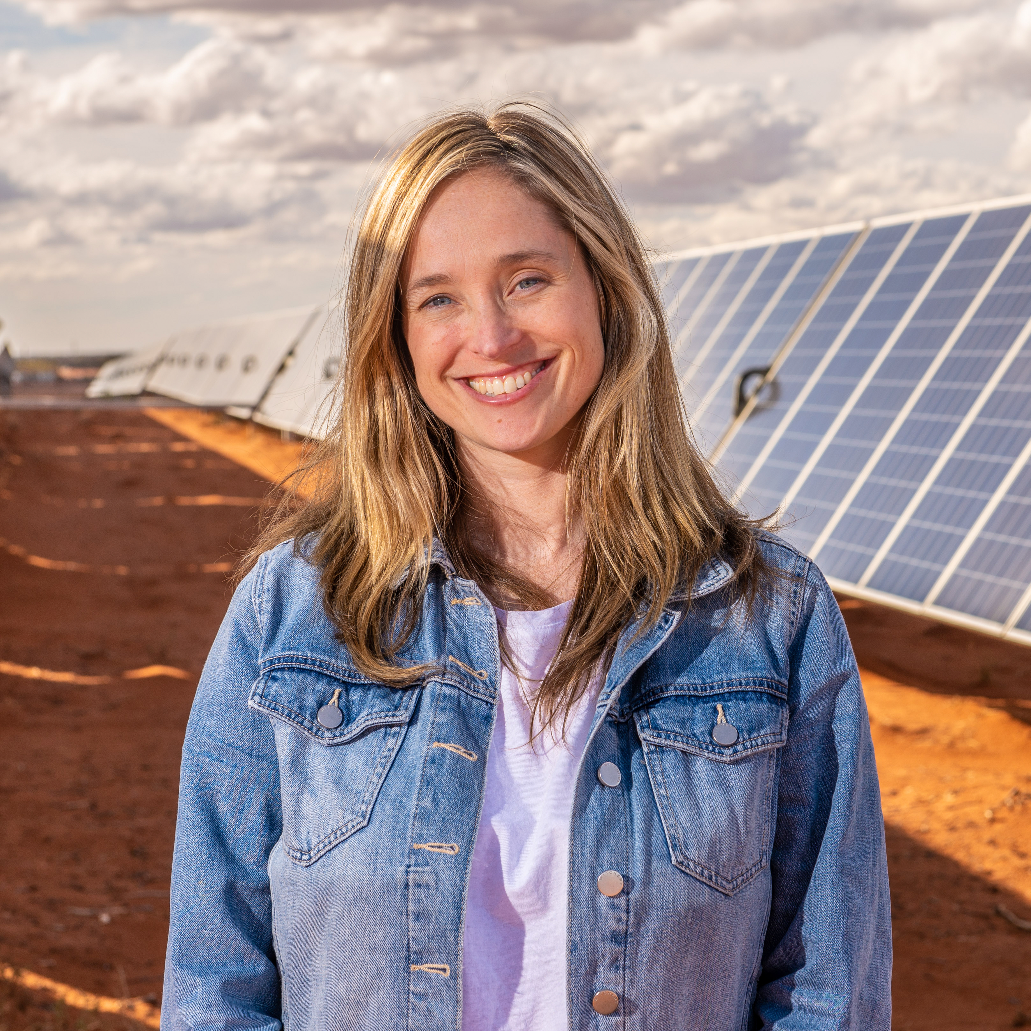 Amanda McKenzie posing in front of solar panels