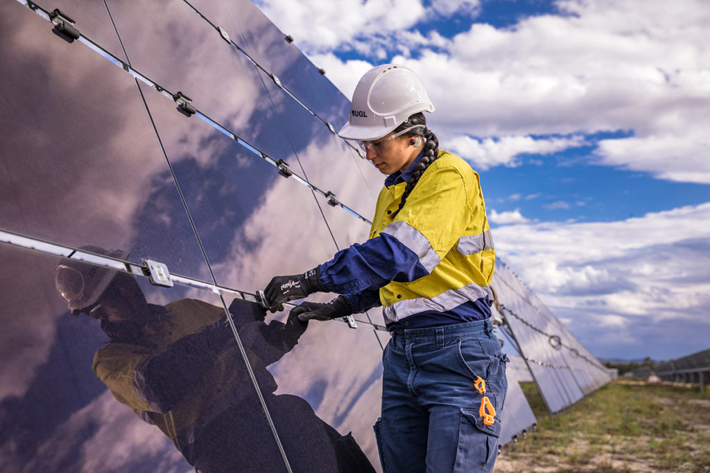 An image of a worker fixing or installing a solar panel.