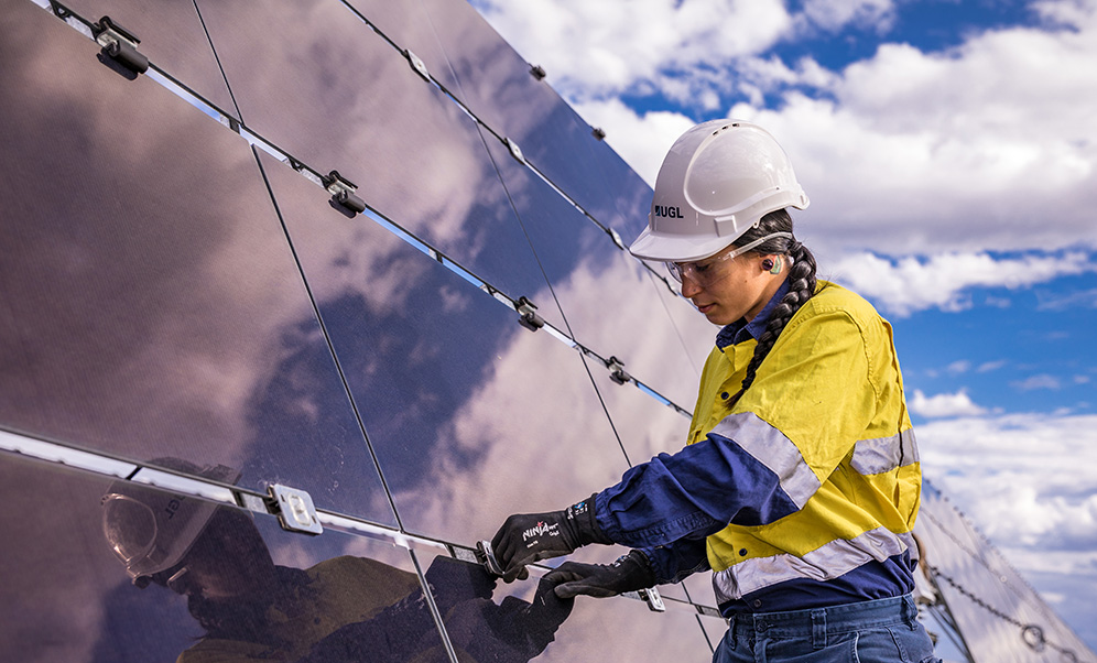 An image of a worker fixing or installing a solar panel.