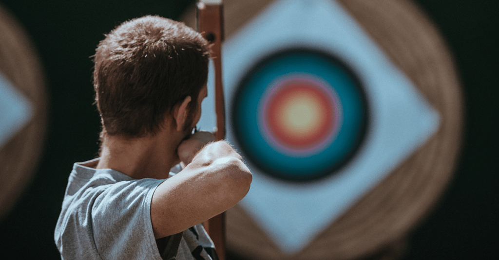 An archer levelling his sights at a bullseye