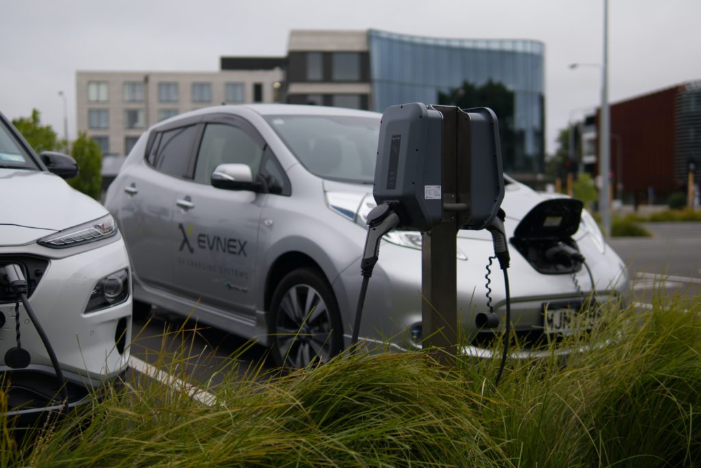 Silver Nissan Leaf's parked and charging at an electric vehicle charging station