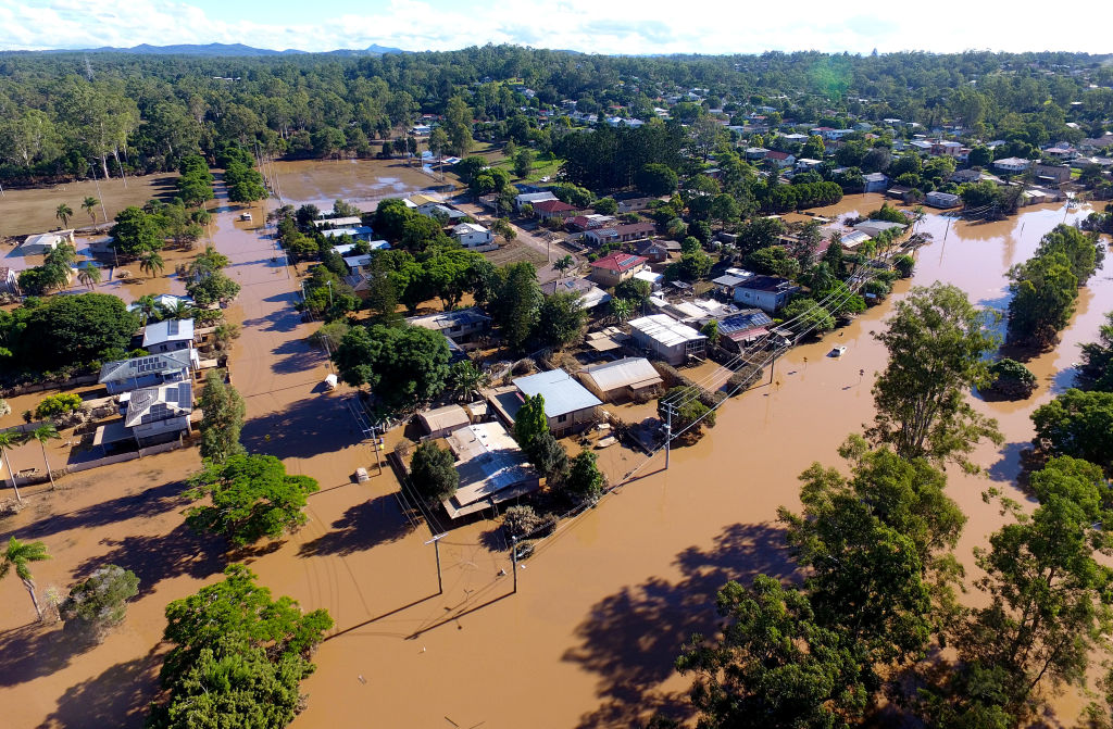An aerial image of a town with houses surrounded by floods