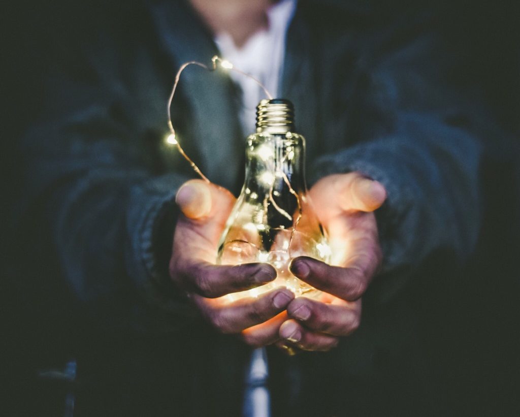 Hands holding out light bulb