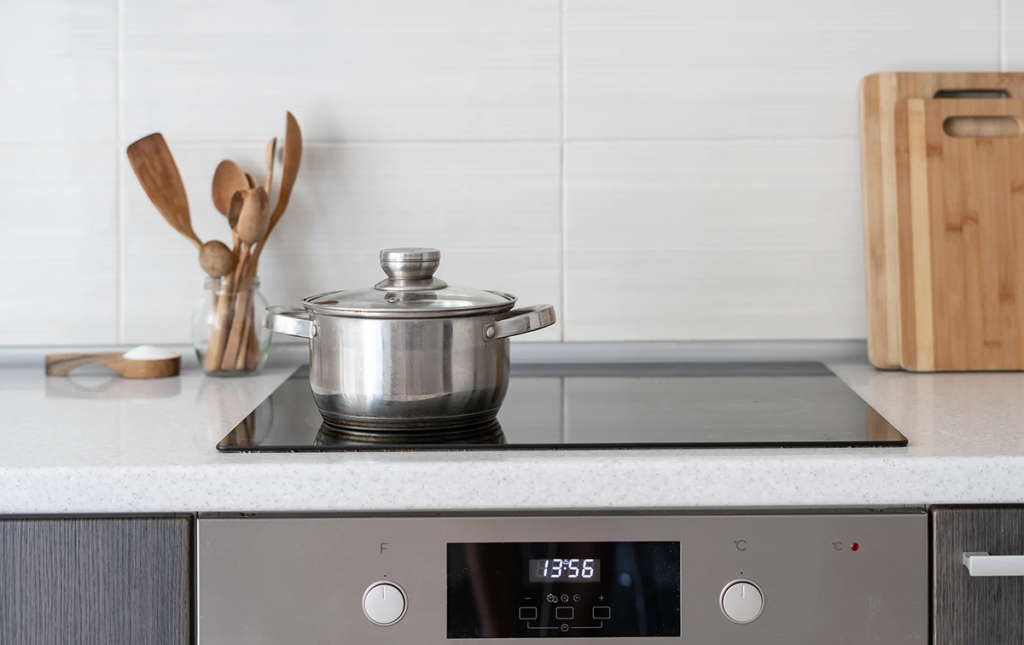 An image of an induction stove top in a kitchen with a pot.
