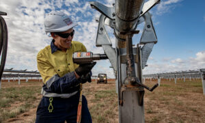 An image of a woman in high vis and a hard hat installing a solar panel.