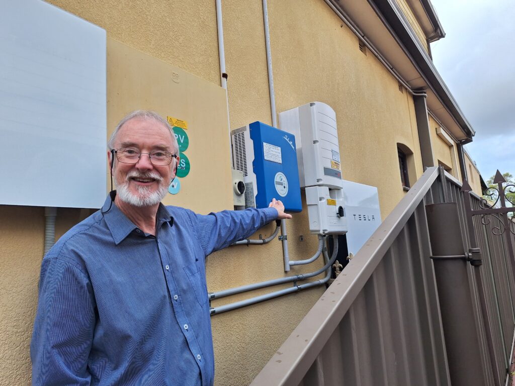 Man pointing to his home battery unit.